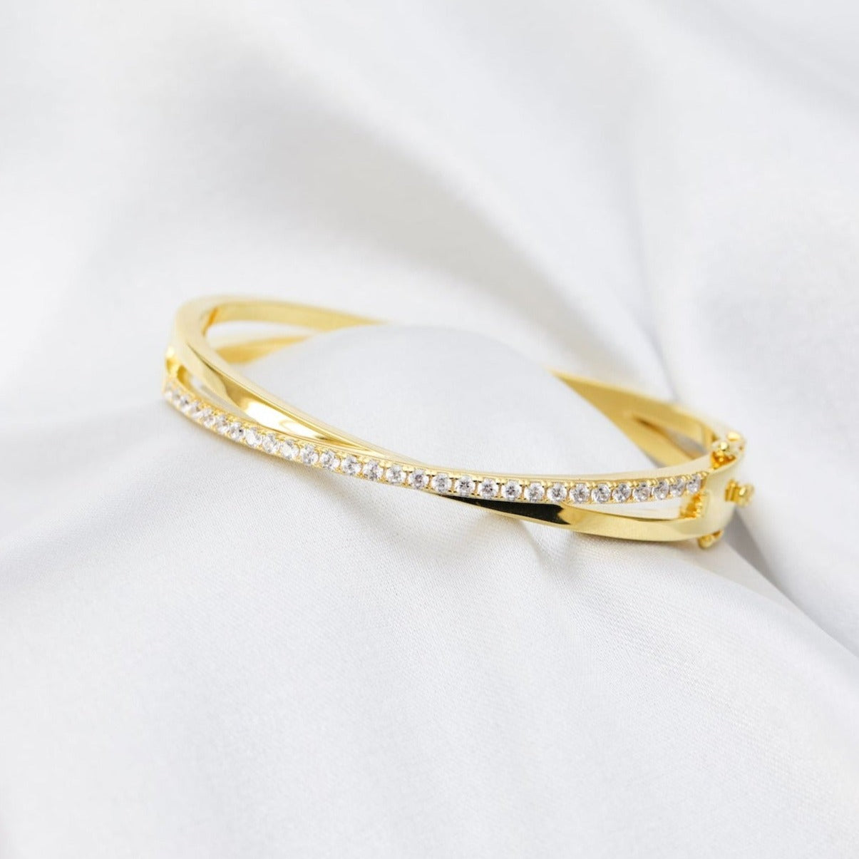 gold plated crossover bracelet with a row of sparkling cubic zirconia stone